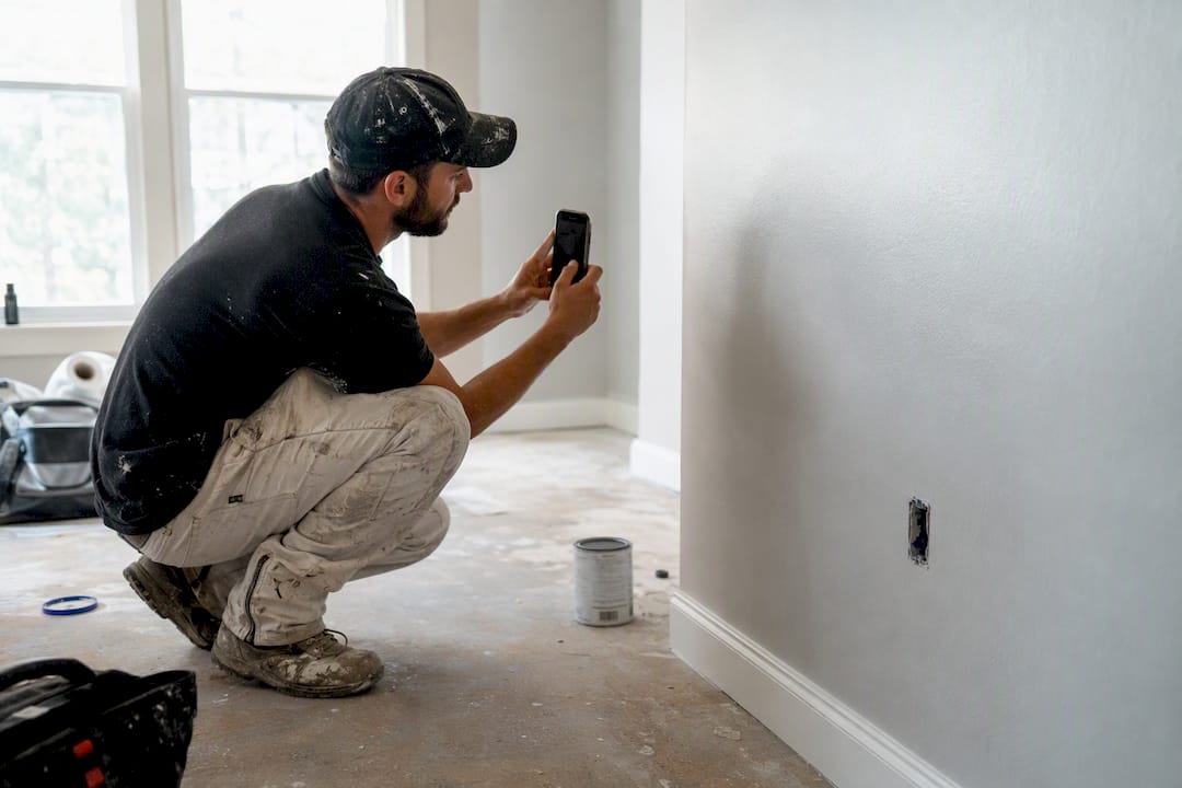 Worker methodically photographing construction site details