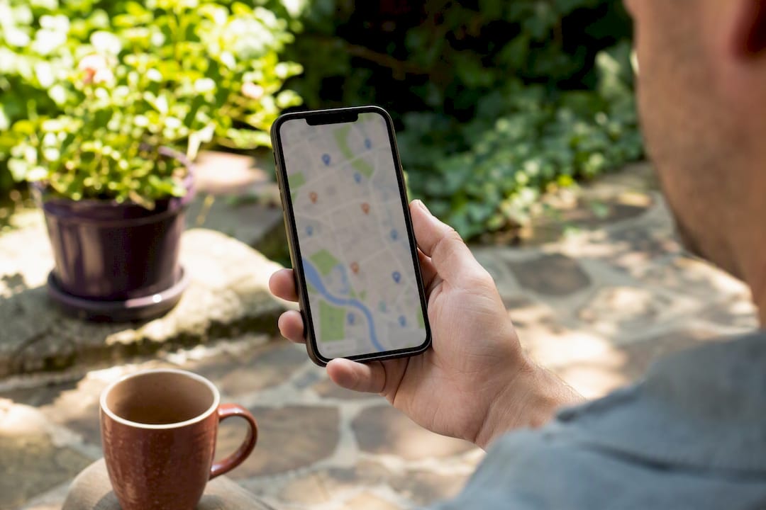 Hand holding smartphone with map and property markers